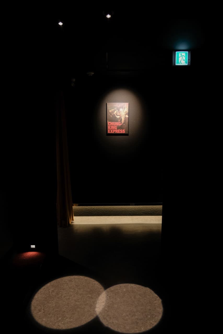 영화 포스터와 원형 조명이 놓인 사이드바 인 시네마의 어두운 복도
